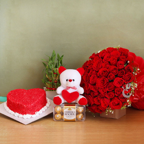 Astounding Bump: A Gift Combo of 50 Red Roses, 16 Pc Ferrero Rocher, 6 Inch Teddy, One Lucky Bamboo, and 0.5 Kg Heart Shape Red Velvet Cake