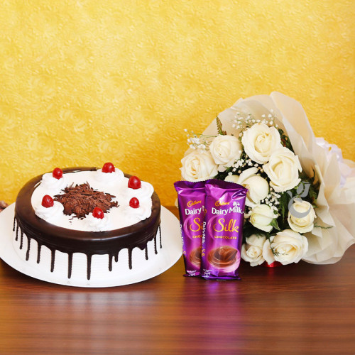 Sweet Carnival: A Gift Combo of 12 White Roses, 0.5 Kg Blackforest Cake and 2 Dairy Milk Silk